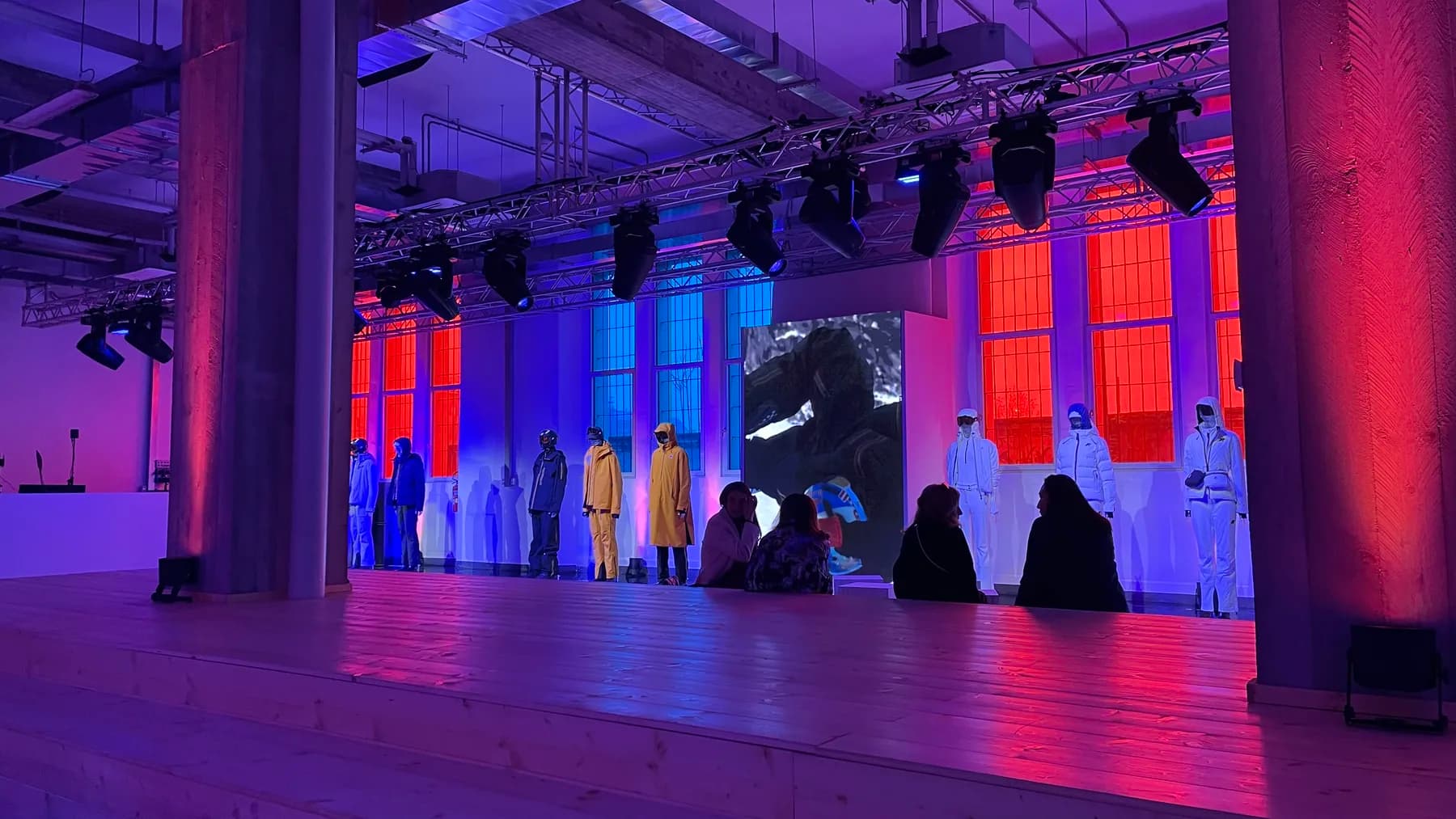 The Montagna Milano venue at BASIC VILLAGE with K-Way alpine looks displayed under red and blue lighting.